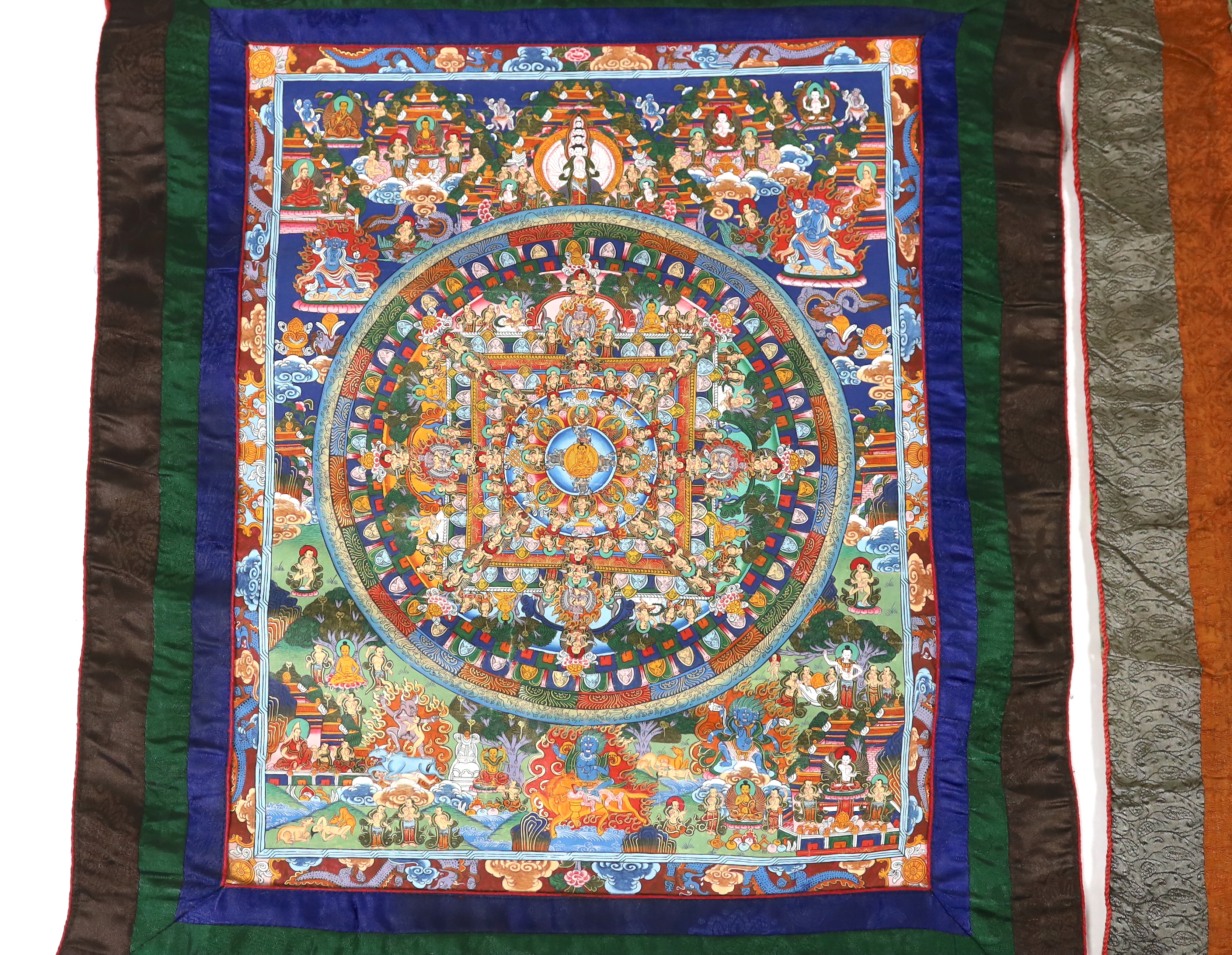 Two Tibetan 20th century Nepalese Thangka and a Burmese Sutra, one Thangka depicting six sections of life, the other a Mandala of Heaven and Earth, 38cm wide, 47cm high (not including silk borders), together with a simpl